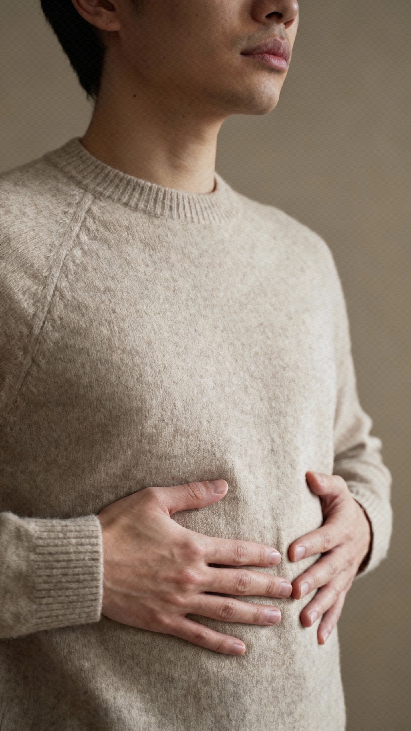 Belly and chest with hands placed, ribcage expanding, neutral sweater