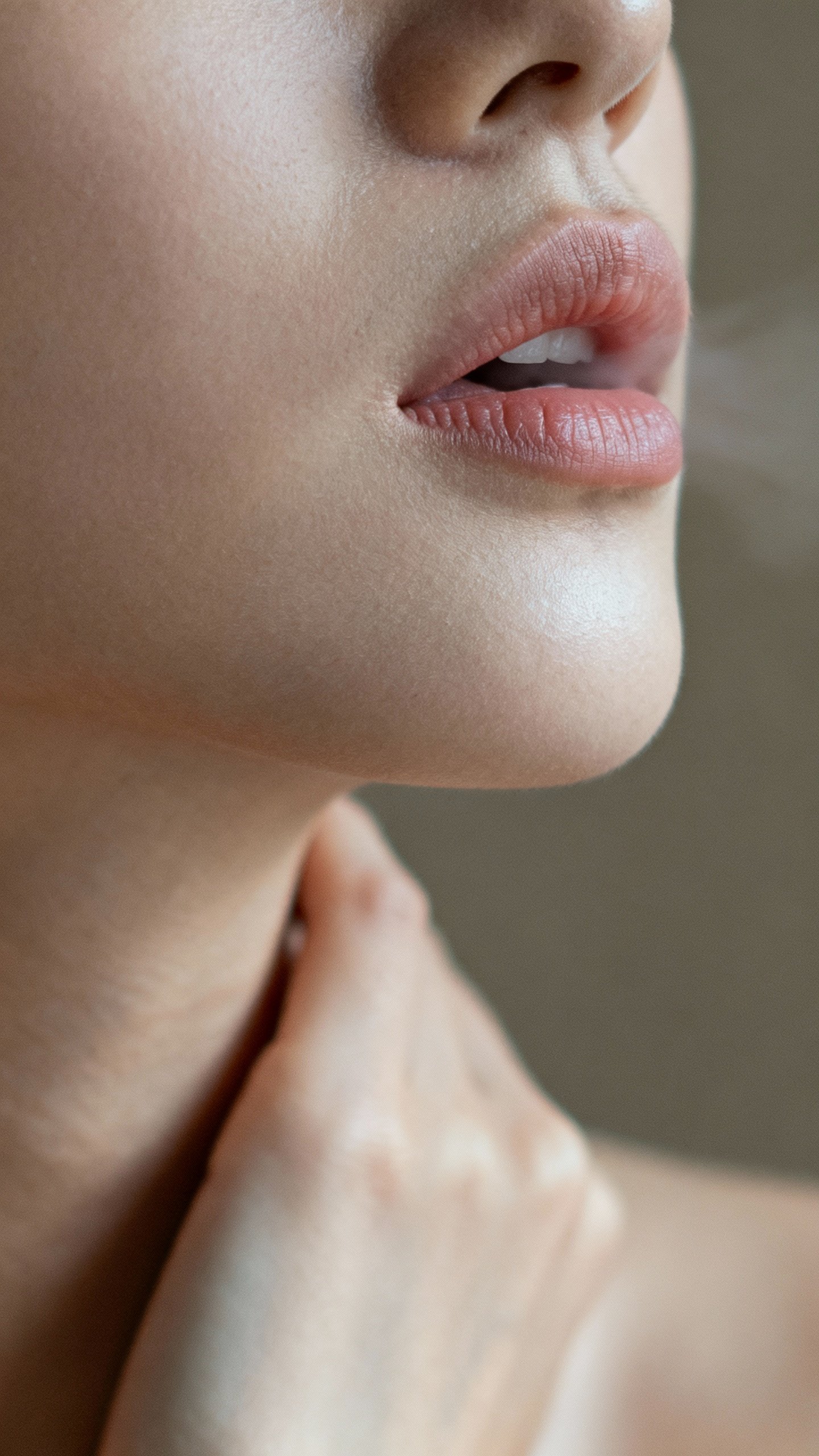Closeup lips gently humming, hand on throat, relaxed jaw