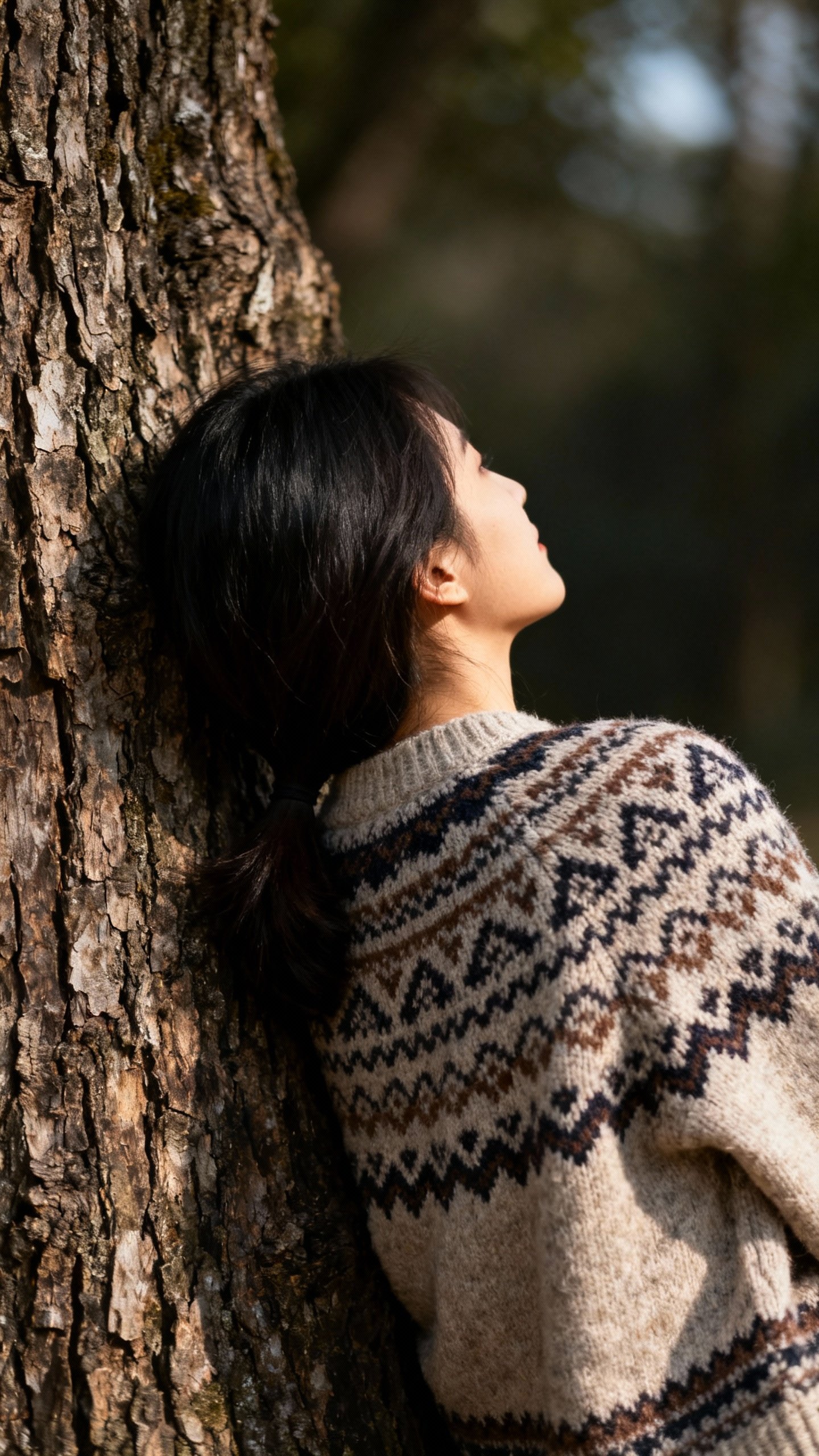 Female leaning back against rough tree bark, mid-back closeup, textured bark and patterned sweater, 