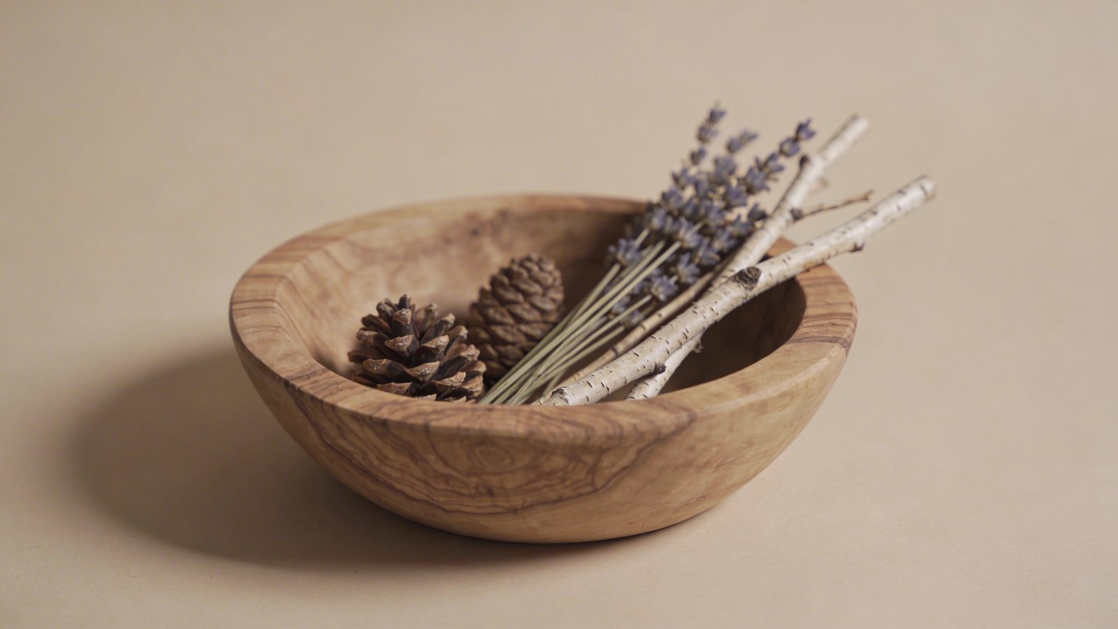 Raw wood bowl, dried botanicals, neutral backdrop.