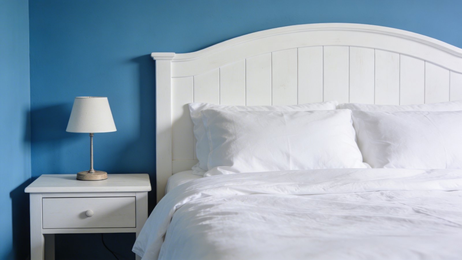 Serene blue bedroom, crisp white linens.