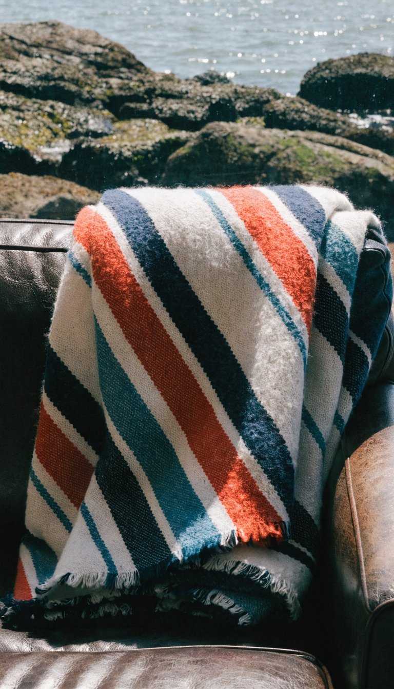 **Coastal-inspired striped throw blanket folded on a couch**
